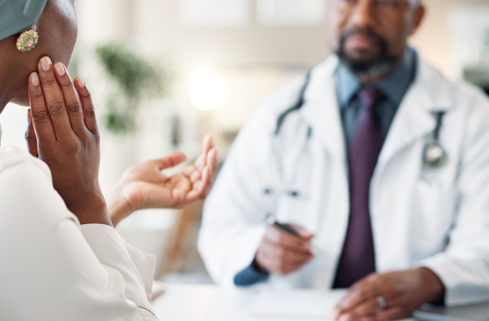 A woman discussing her jaw discomfort with a dentist during a consultation.