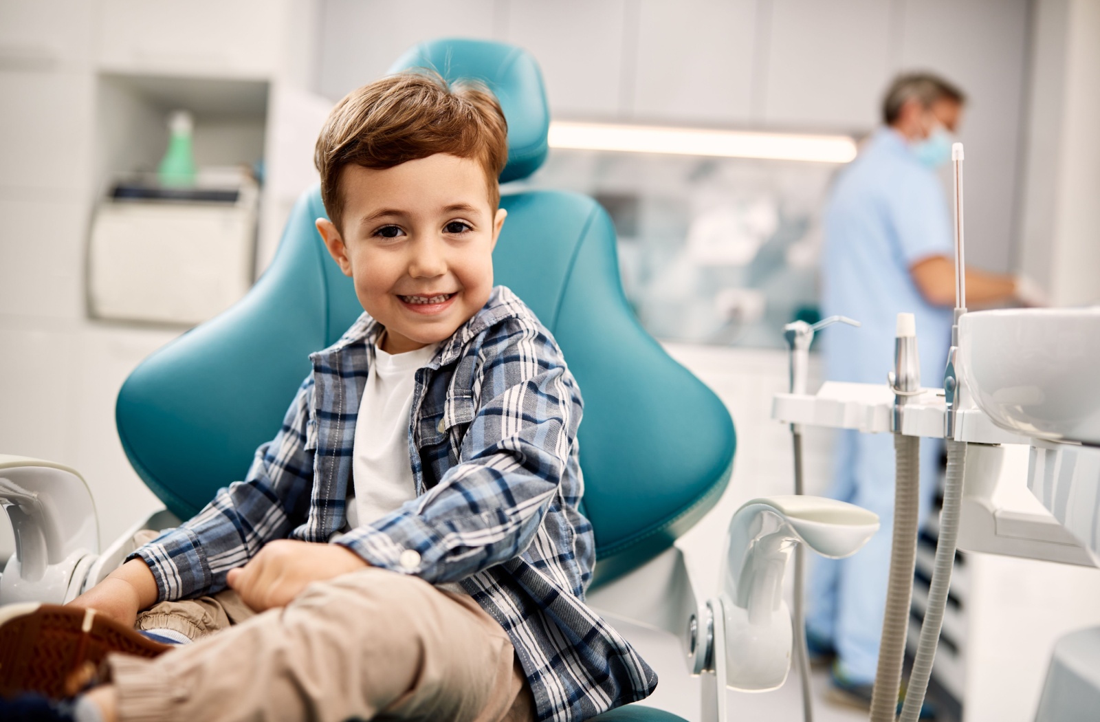 A young dental patient sitting in an exam room.